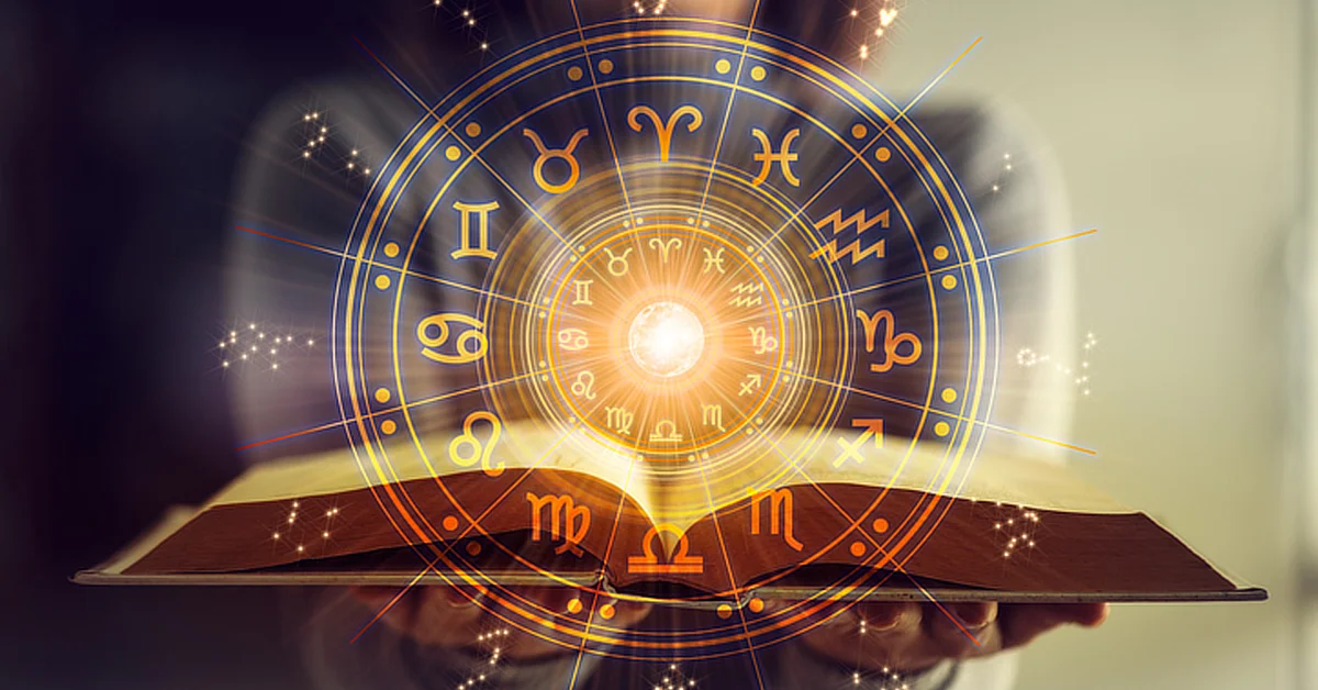 An open book with a glowing astrological wheel hovering above it, featuring zodiac symbols radiating from a bright center.