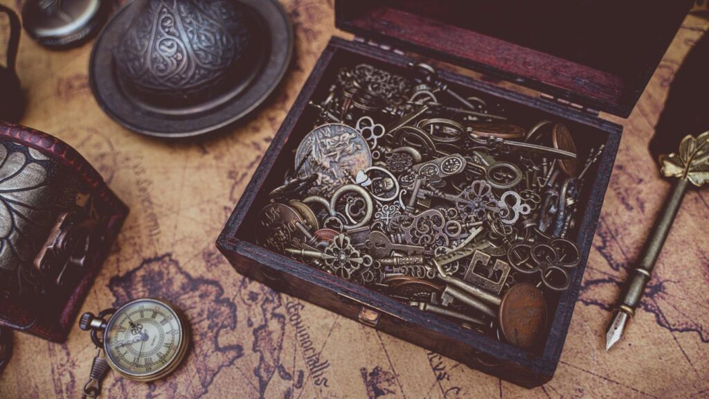 A wooden box filled with antique keys and vintage items on an old map.