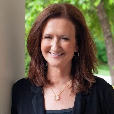 Portrait of Debra Roberts standing with trees in background