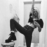 Client testimonial image featuring a woman, Morgan Day Cecil, posing playfully in a mirror selfie, wearing a cropped top, high-waisted pants, and boots.